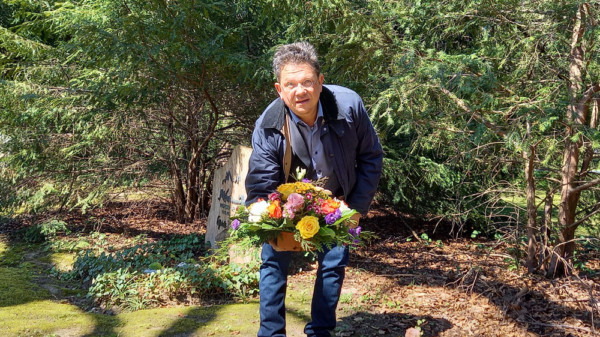 Dr. Andreas Philippi legt einen Blumenstrauß nieder